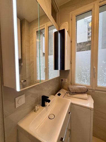 une salle de bain avec un lavabo et un miroir dans l'établissement Studio Convention Porte de Versailles, à Paris