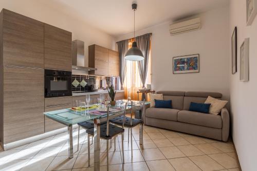 una cucina e un soggiorno con un tavolo e un divano di La Tana di Mart - Zona Navigli - Vicino Metro a Milano