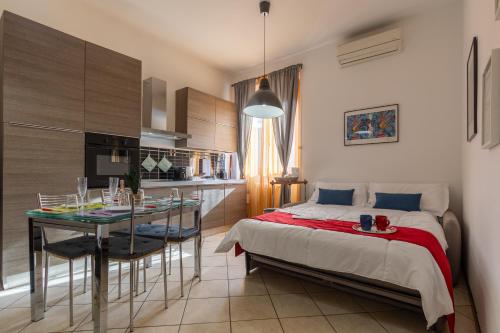 una camera da letto con un letto, un tavolo e una cucina di La Tana di Mart - Zona Navigli - Vicino Metro a Milano