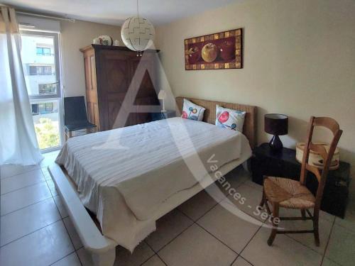 une chambre avec un grand lit et une chaise dans l'établissement T2 avec terrasse, clim dans le salon, parking a quelques pas des plages, à Sète