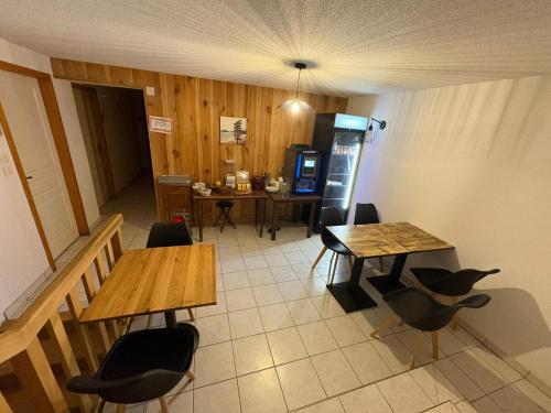 a room with two tables and chairs and a kitchen at Auberge du Ruxelier J&D in Cheniménil