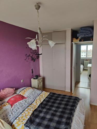 une chambre avec un lit avec un mur violet dans l'établissement Le nid de la Garonne, à Toulouse