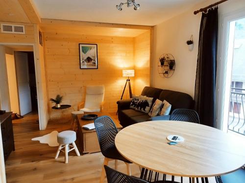 una sala de estar con una mesa y un sofá en Bel appartement proche Saint Lary Soulan, en Vielle-Aure