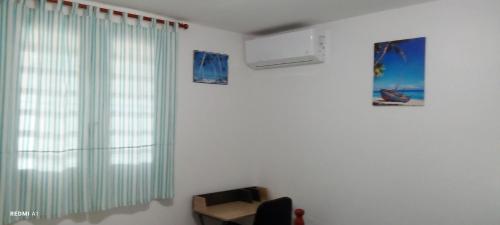 a room with a window and a desk and a chair at Logement d'affaires et de séjours de groupes du Robert in Le Robert