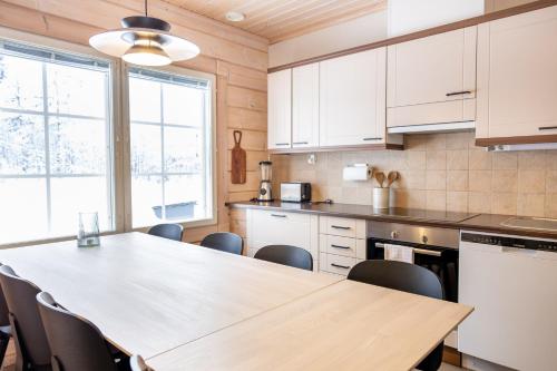 a kitchen with a wooden table and chairs at Villa Pyry in Vuokatti