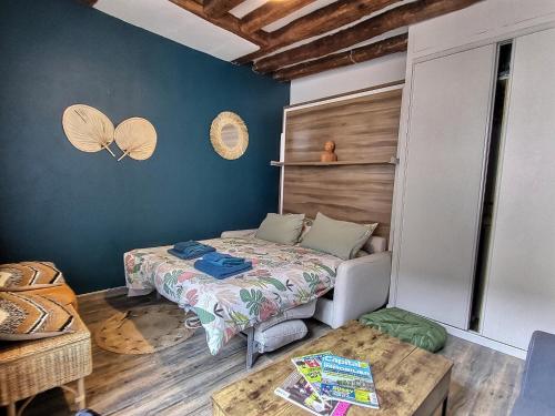 une petite chambre avec un lit et une table dans l'établissement Studio Colonial Checkpoint 2 étoiles Mennecy Netflix Fibre, à Mennecy