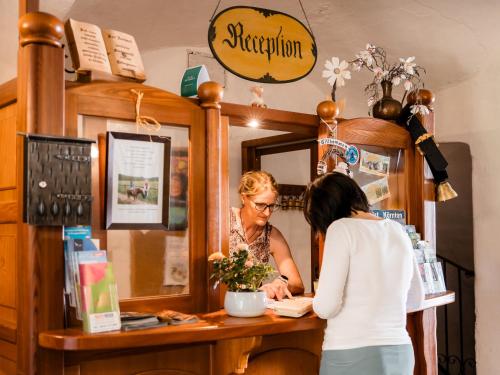 a woman standing at a cash register in a store at Familienbauernhof Glawischnig-Hofer in Gmünd in Kärnten