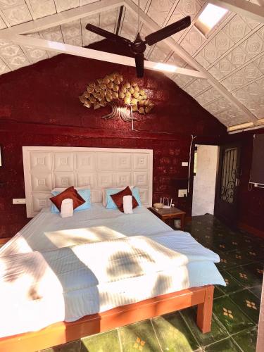a bedroom with a large bed with a red wall at Sabera Heritage Homestay in Sakleshpur