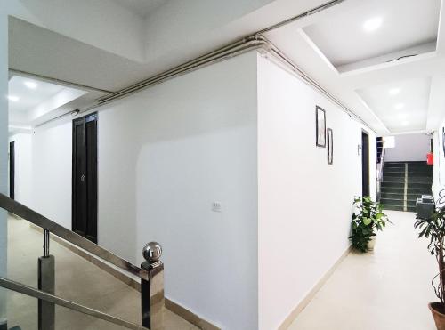 a hallway of a house with white walls and stairs at Hotel Prime By The Premium Villa in New Delhi