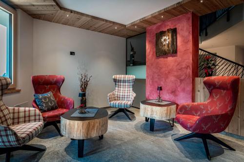 a living room with chairs and a table at Arnica Alpin Lodge in Cavedago
