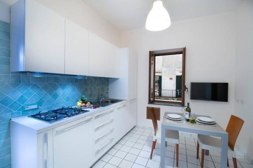 a kitchen with a stove and a table with chairs at Ravello House in Ravello