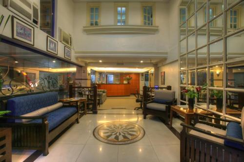 a lobby with couches and tables in a building at Fersal Hotel - Manila in Manila
