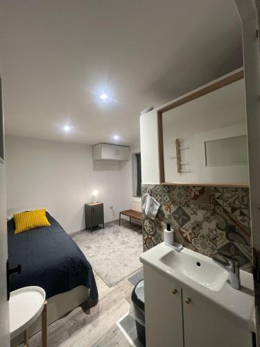 a bedroom with a bed and a bathroom with a sink at Southern Sun in Tilburg