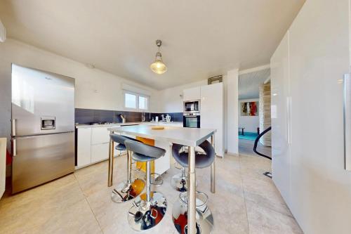 une cuisine avec une table et deux tabourets dans l'établissement Appart 1 Cèsière - Appartement confortable au calme, à Annecy