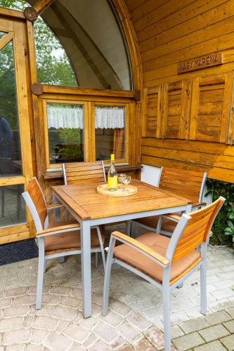 a wooden table and chairs on a patio at Gesztenye Nyaralópark in Balatonudvari