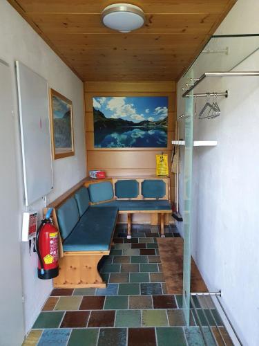 a waiting room with a blue couch and a fire extinguisher at Haus Mangeng in Vandans