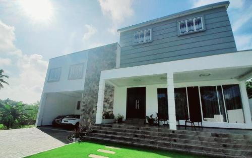 a house with a green lawn in front of it at Hotel Vista in Kamburugamuwa