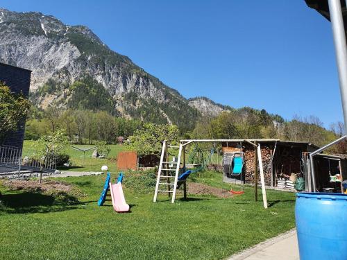 a playground in a yard with a mountain in the background at Haus Mangeng in Vandans