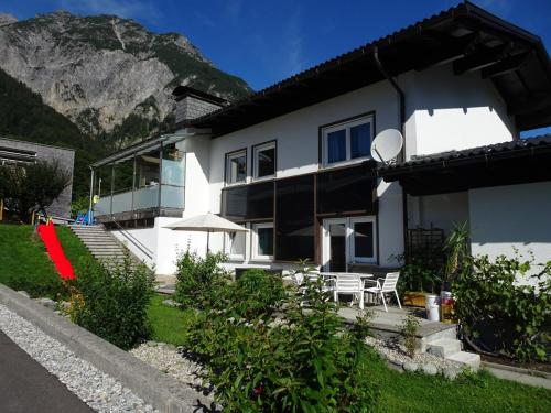 a white house with a table and chairs and a mountain at Haus Mangeng in Vandans