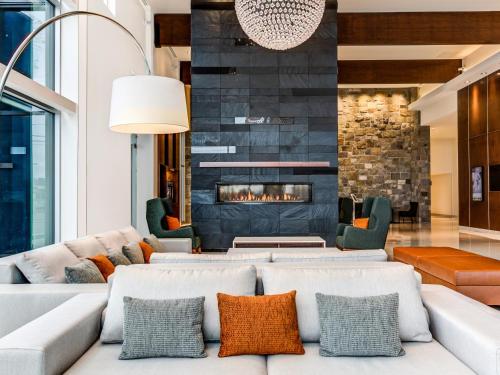 a living room with a couch and a fireplace at OTL Gouverneur Saguenay in Saguenay