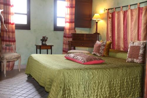 une chambre avec un lit avec une couette verte dans l'établissement Chambre Zagora, Riad 8 au village naturiste Couple only, au Cap d'Agde