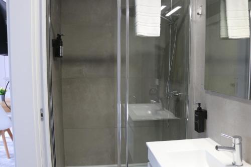 a bathroom with a glass shower and a sink at 9 min Metro to Downtown -Remote working - Free Parking in Porto