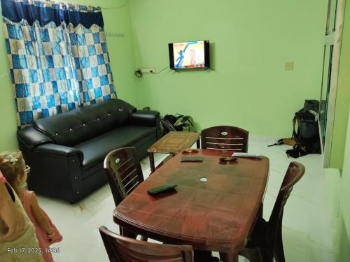 a living room with a table and a leather couch at Villa VOC in Puducherry