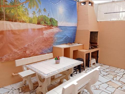 a patio with a table and a mural of a beach at Casa Susana in Atouguia da Baleia