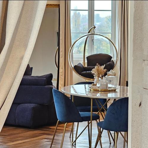 une salle à manger avec une table en verre et des chaises bleues dans l'établissement Le Boudoir du Beaujolais, à Belleville-en-Beaujolais