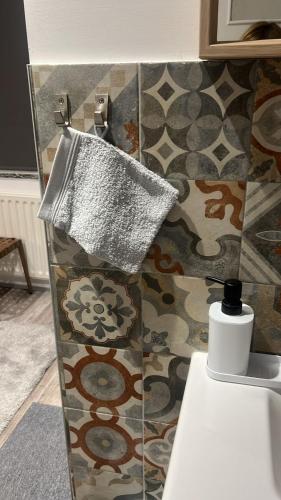 a towel hanging on the wall of a bathroom at Southern Sun in Tilburg