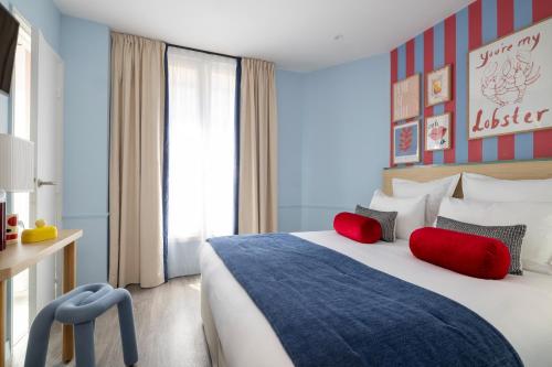 a hotel room with a large bed with red pillows at Hotel La Folie des Pres - Saint-Germain-des-Pres in Paris