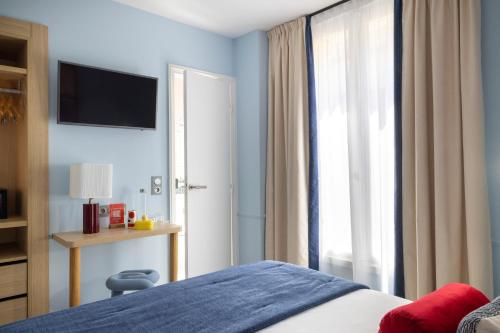 a bedroom with a bed and a large window at Hotel La Folie des Pres - Saint-Germain-des-Pres in Paris