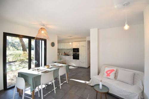 une cuisine et un salon avec une table et un canapé dans l'établissement Barranx - Hossegor appartement pour 4 personnes dans le centre ville, à Soorts-Hossegor