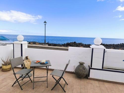 a patio with a table and chairs and the ocean at Casa Lila, paz junto al mar in Guatiza