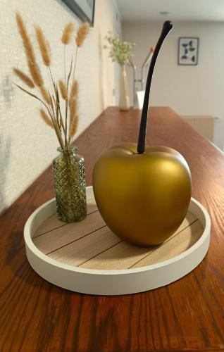 a golden apple sitting on a table with a vase at Hoeve Hofgaarde in Heers