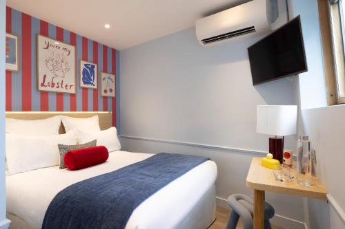 a hotel room with a bed and a tv at Hotel La Folie des Pres - Saint-Germain-des-Pres in Paris