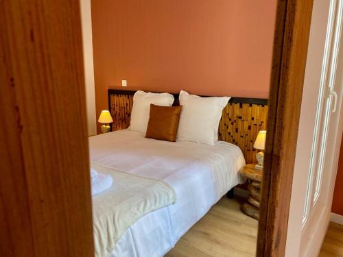 a bedroom with a bed with white sheets and pillows at Mabel - T3 Climatisé, Wifi, Quartier haut in Sète