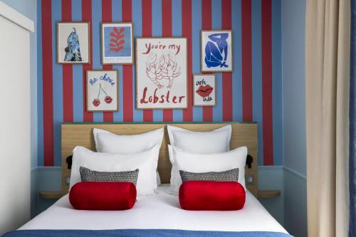 a bedroom with a bed with red and white pillows at Hotel La Folie des Pres - Saint-Germain-des-Pres in Paris