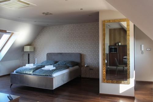 a bedroom with a bed and a mirror at AB Stúdió in Szombathely