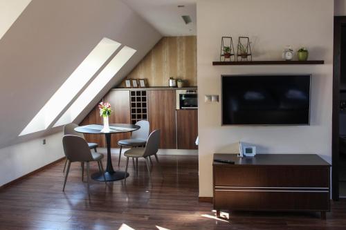 a living room with a table and chairs and a tv at AB Stúdió in Szombathely