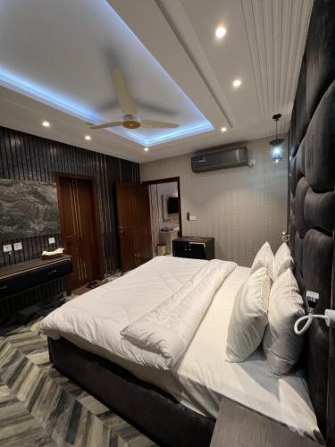 a bedroom with a large bed in a room with a piano at Courteous Hotel in Islamabad