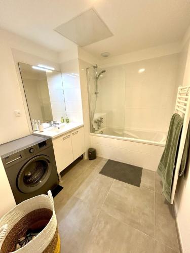 La salle de bains est pourvue d'un lave-linge, d'un lavabo et d'une douche. dans l'établissement Grand appartement neuf à 150m de la plage du Platin, à Saint-Palais-sur-Mer