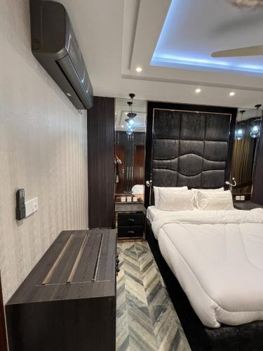 a bedroom with a large bed and a table at Courteous Hotel in Islamabad