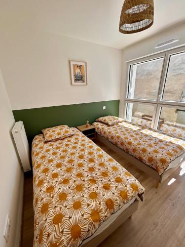 une chambre avec deux lits et une fenêtre dans l'établissement Grand appartement neuf à 150m de la plage du Platin, à Saint-Palais-sur-Mer