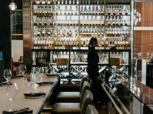 a woman standing behind a bar in a restaurant at OTL Gouverneur Saguenay in Saguenay