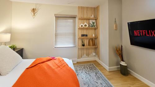 a bedroom with a bed with an orange blanket on it at 4 BR - King beds - perfect for HPU, Furniture Market, Greensboro, Winston in High Point