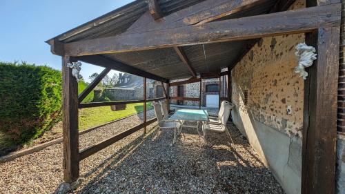 a patio with two chairs and a table in a building at Évasion cosy au cœur du Perche in Boissy-lès-Perche