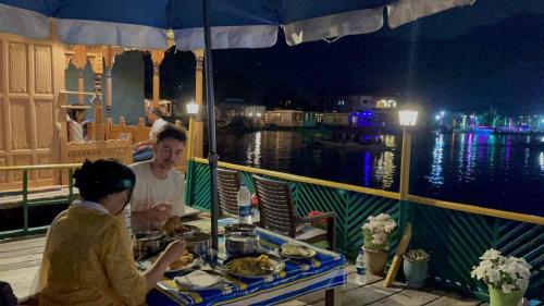 a man and a woman sitting at a table on a boat at Hotel sea face in Srinagar