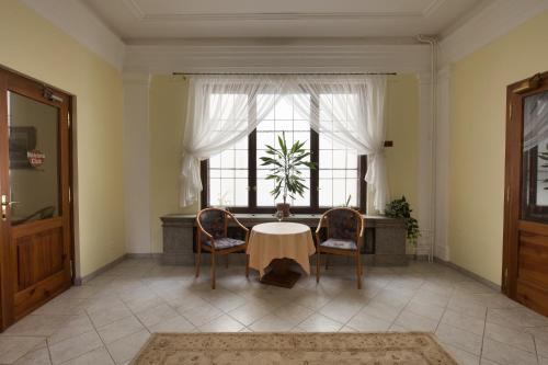 a room with a table and two chairs and a window at Hotel U Černého orla in Telč
