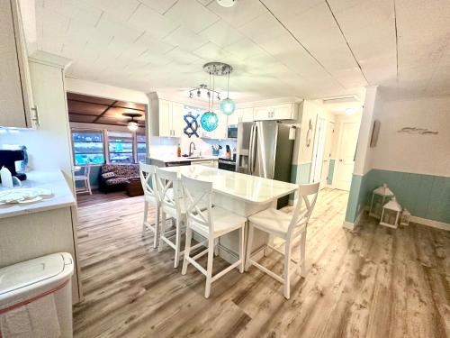 a kitchen and living room with a white table and chairs at Cabin by the Sea - Waterfront Direct Gulf Access- Pontoon Boat Rental On Site or Bring Your Boat- Paddlecraft included in Hernando Beach